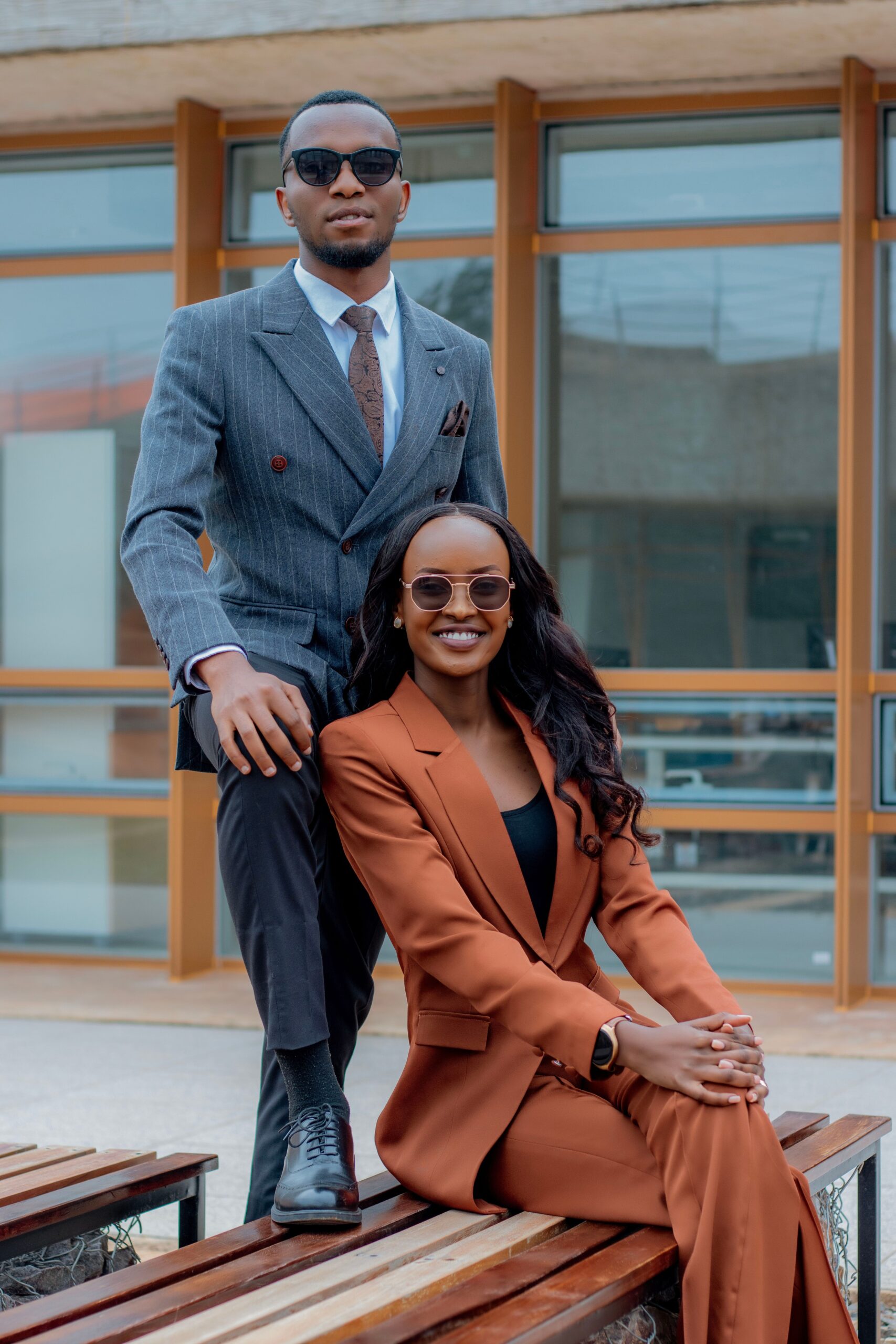 A portrait of two elegantly dressed professionals outdoors, showcasing modern business fashion.